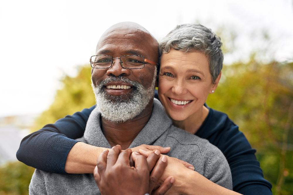 Older black man and older white woman smiling together, huntsville al