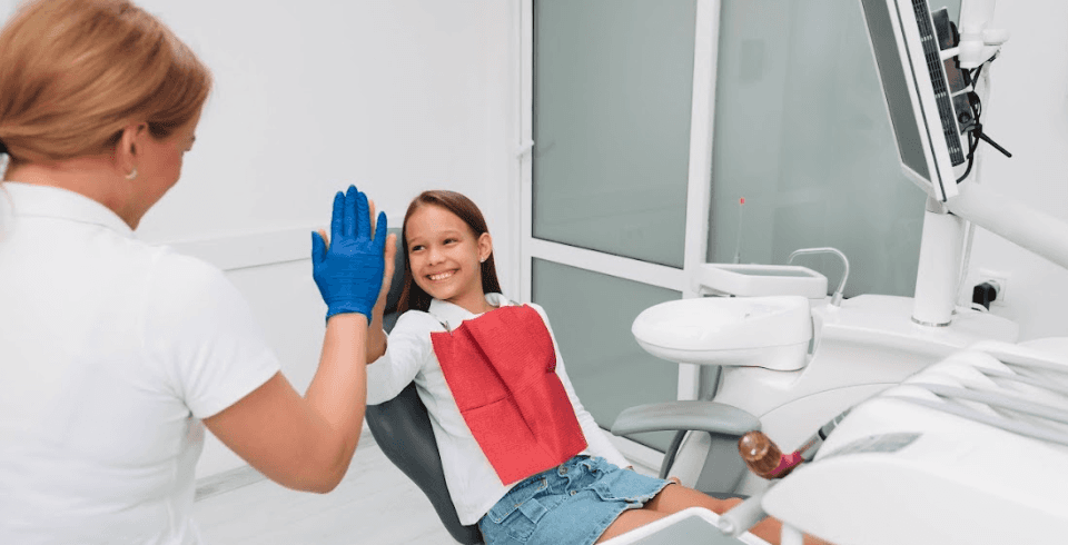 Child high-fiving dentist | Children's dentist in Huntsville AL