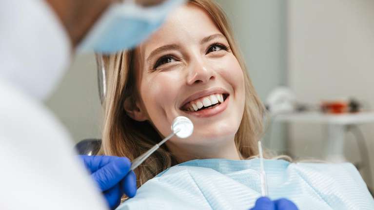 A woman receiving a dental exam Huntsville AL