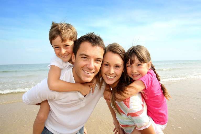 Family smiling together on the beach, huntsville al