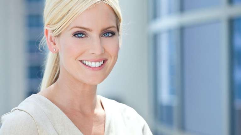 Middle aged blonde woman smiling after dental discount, Huntsville AL