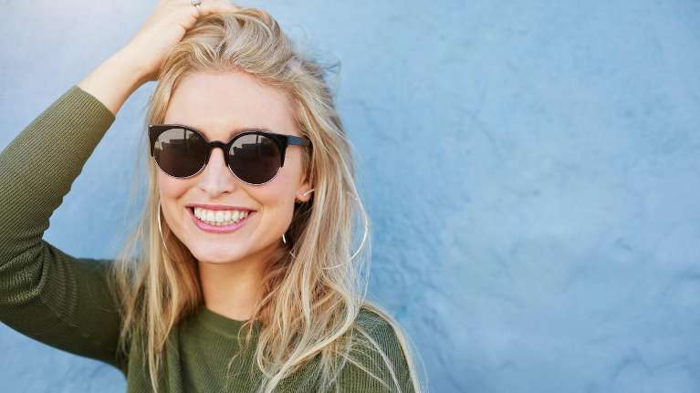 woman with sunglasses smiling | teeth whitening huntsville al
