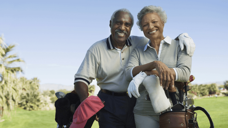 Two older black people smiling together on a golf course, huntsville al