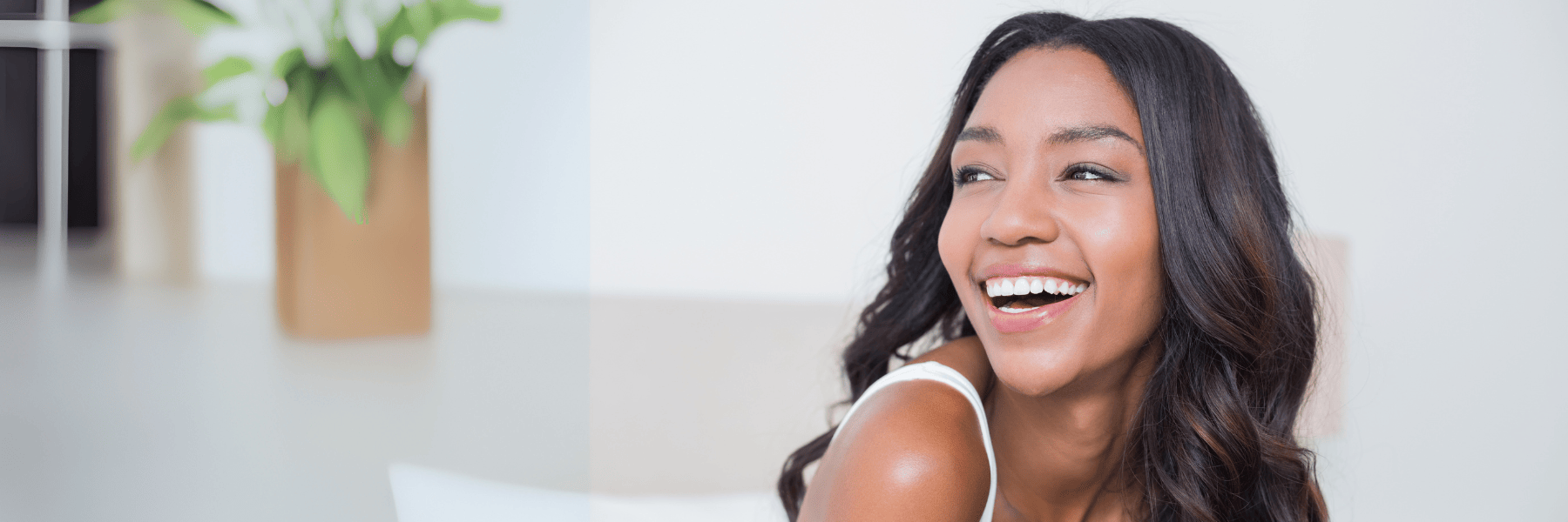 A laughing woman sitting on a couch in Huntsville